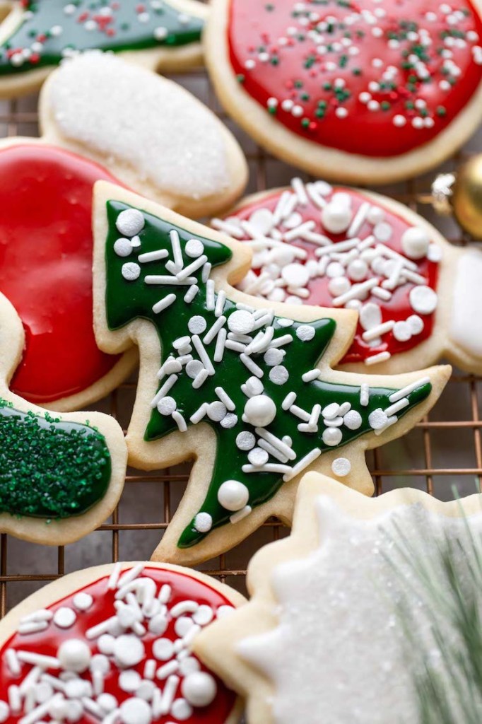 A cooling rack filled with decorated Christmas cookies.