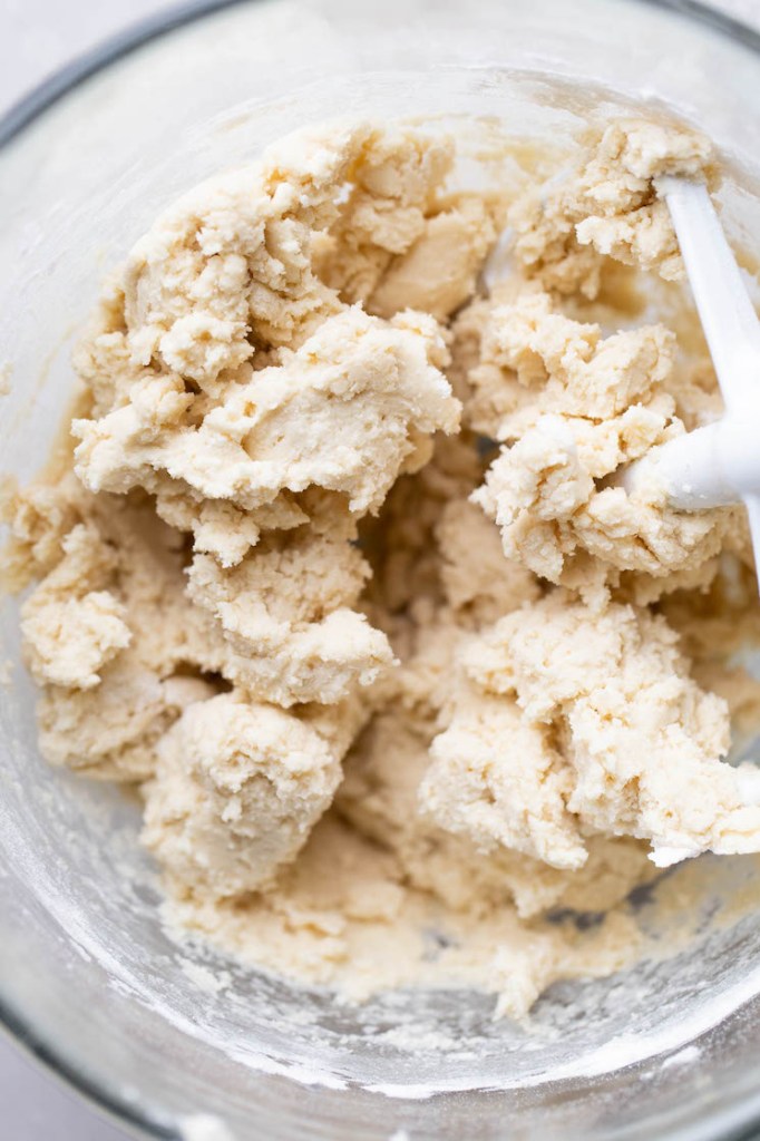 A glass mixing bowl holding finished cookie dough.