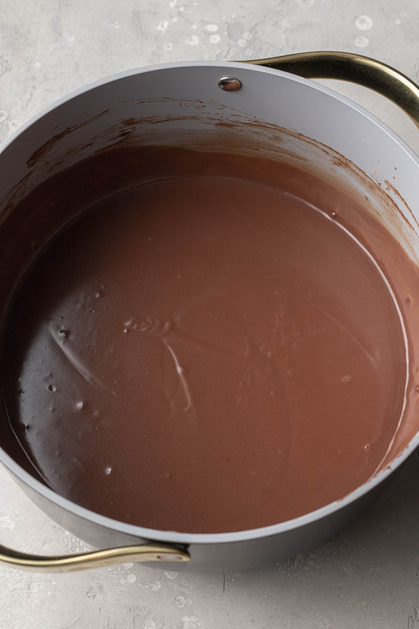 An overhead view of homemade chocolate pudding in a saucepan. 