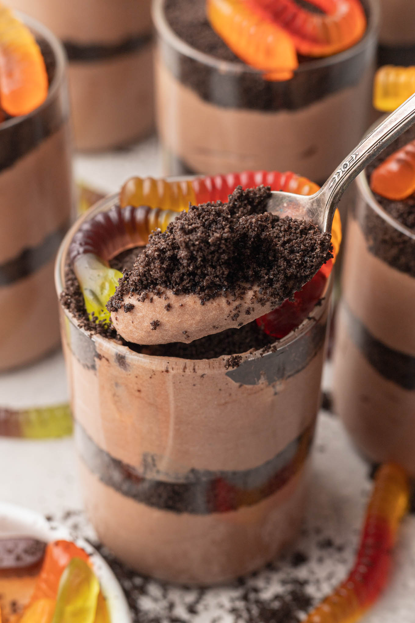 A spoonful of chocolate pudding and Oreo crumbs, from a cup of dirt. 