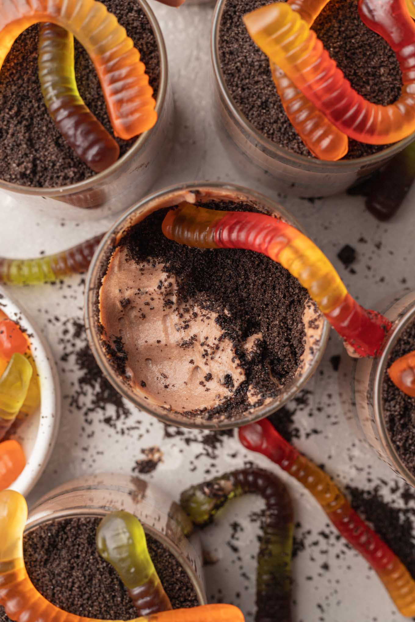 An overhead view of Oreo dirt pudding cups topped with gummy worms. 