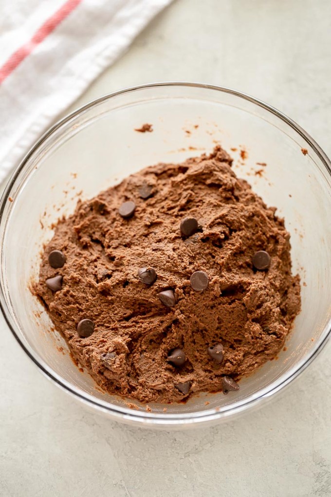 A glass bowl filled with double chocolate chip cookie dough.