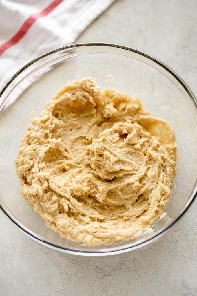 A glass bowl with butter, sugar, eggs, and vanilla mixed together.