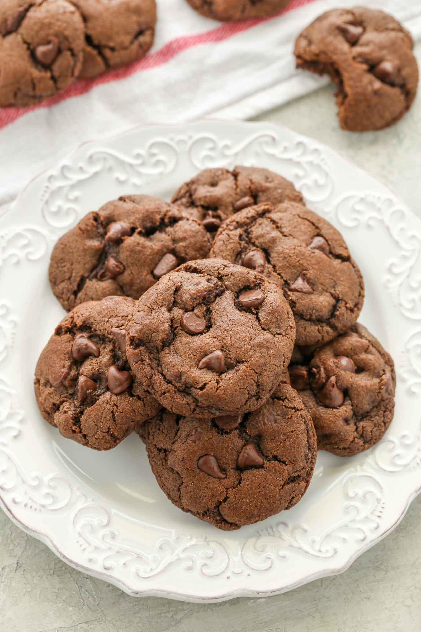 A white plate filled with chocolate cookies and more around it.