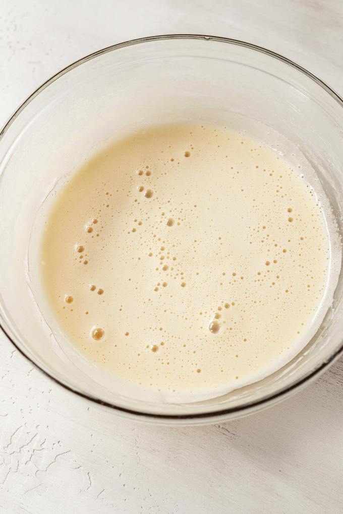 Frothy, cooked eggs in a glass mixing bowl.