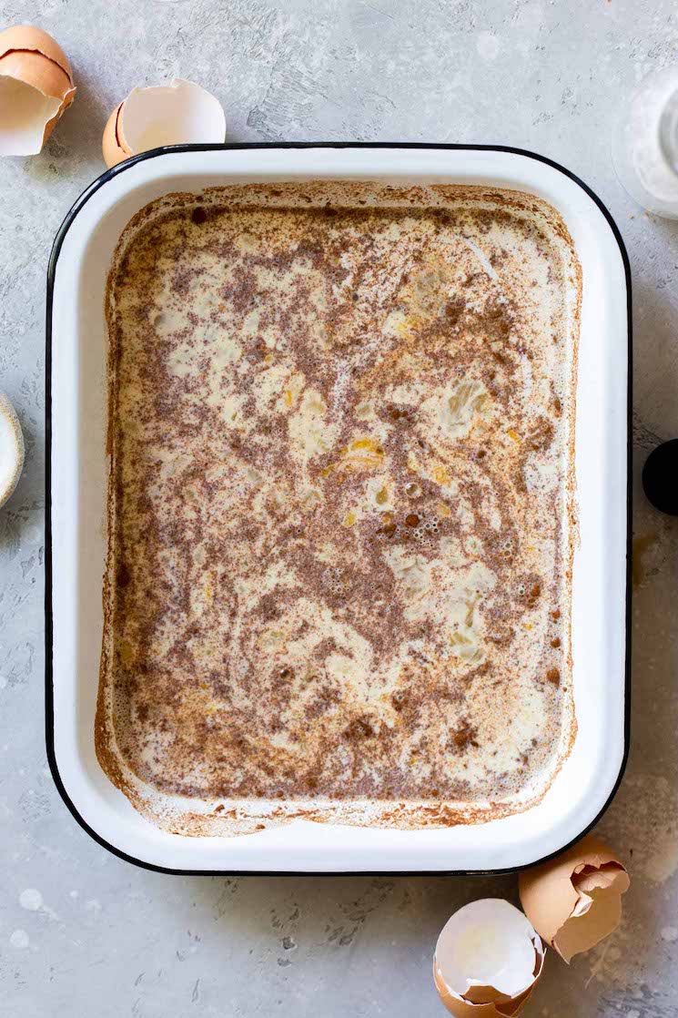 A baking pan filled with the egg mixture ready to dip the pieces of bread into before cooking.