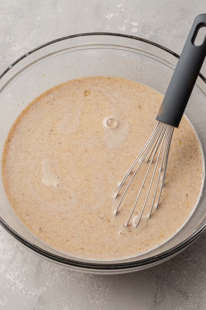 A glass mixing bowl full of spiced custard.