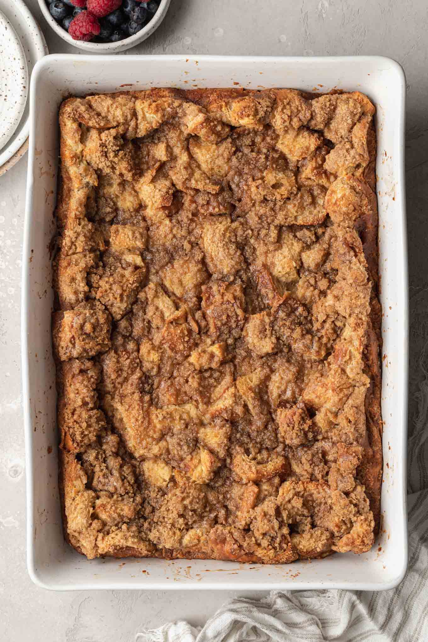 An overhead view of a french toast breakfast casserole topped with crumb topping. 