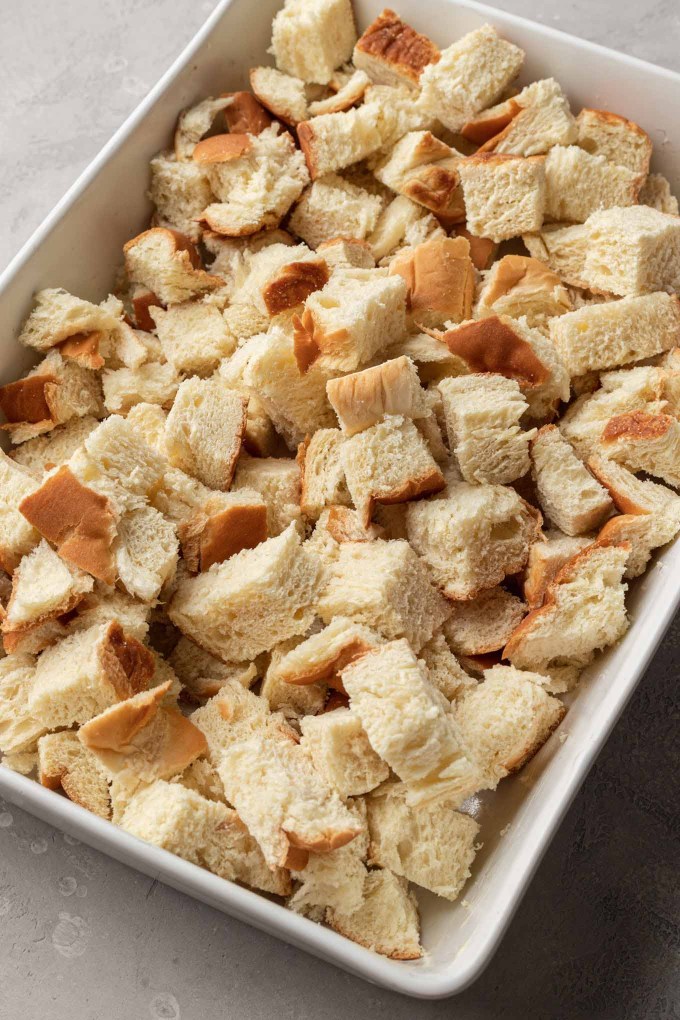 Challah bread cubes in a white casserole dish. 