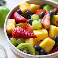 A white bowl filled with fresh fruit salad.