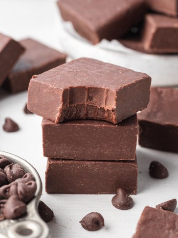 Three pieces of fudge stacked on top of each other. The top piece has a bite taken out of it.