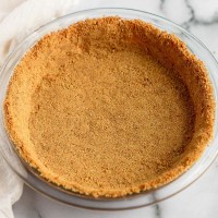 A graham cracker crust pressed into a glass pie dish.