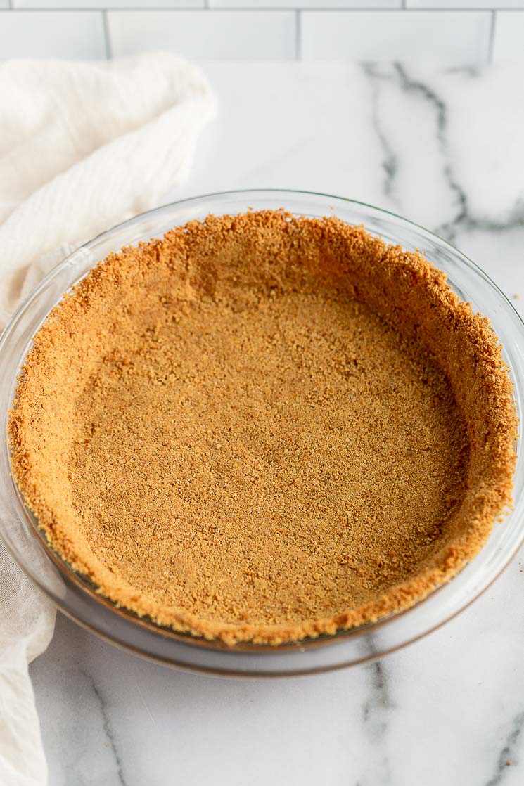 A baked graham cracker crust in a pie dish.