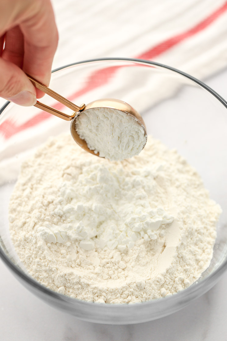 A glass bowl filled with all-purpose flour and two tablespoons of cornstarch.