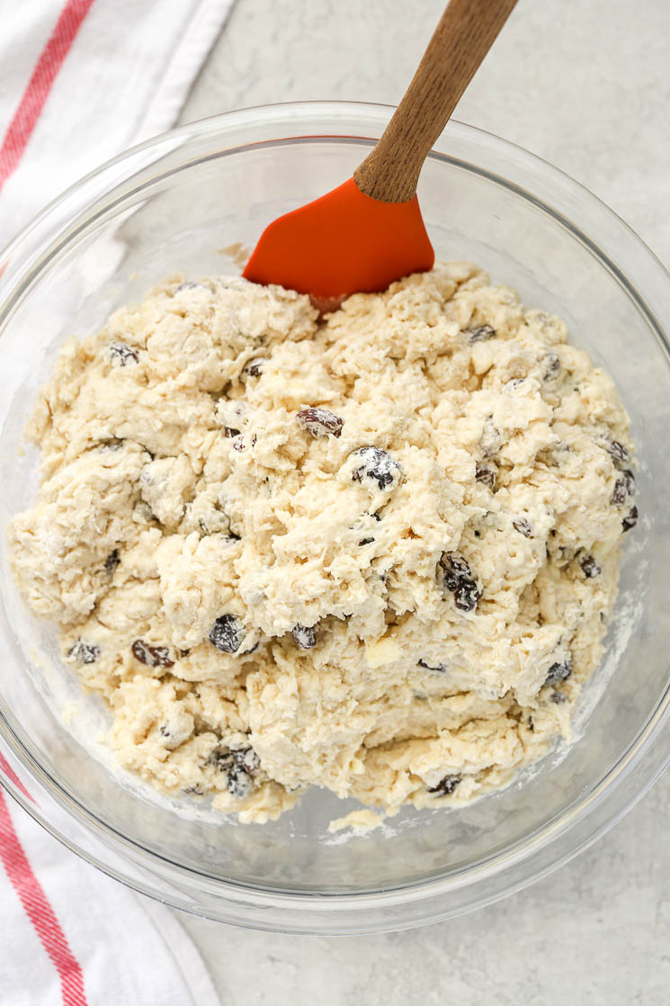 A clear glass bowl filled with Irish Soda Bread dough sitting on top of a red and white napkin. 