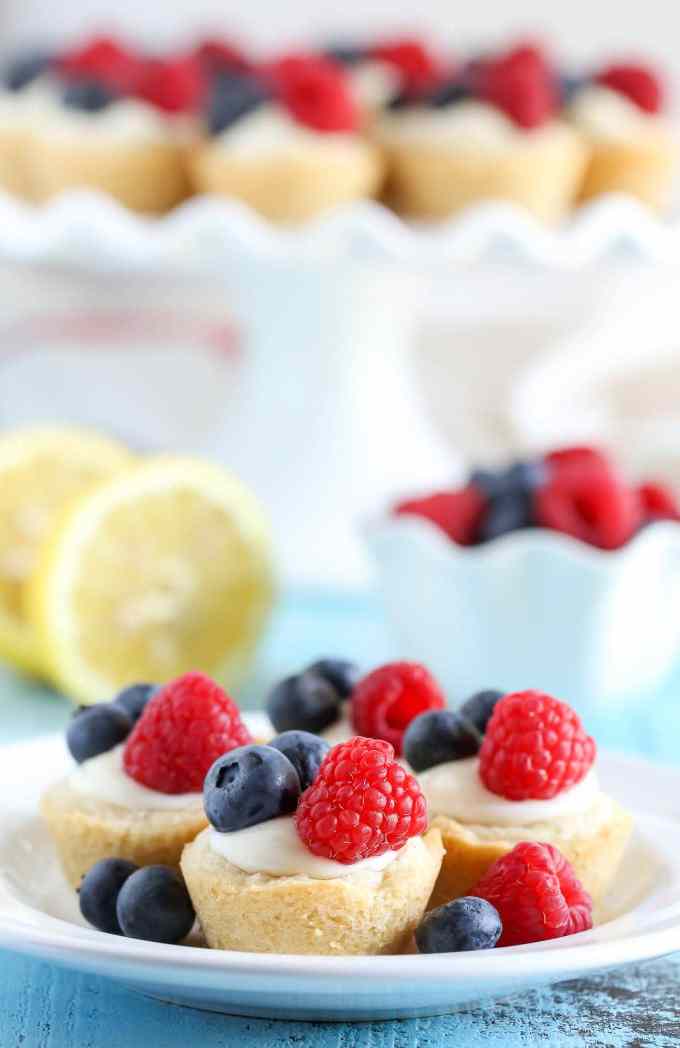 Sugar cookie cups filled with a no-bake lemon cream cheese filling and topped with fresh berries. These Lemon Berry Cheesecake Sugar Cookie Cups make the perfect summer dessert!