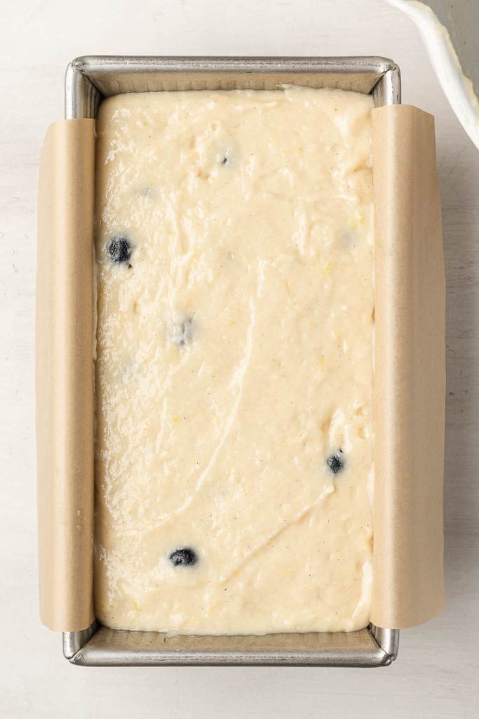 An overhead view of an unbaked lemon blueberry bread in a loaf pan. 
