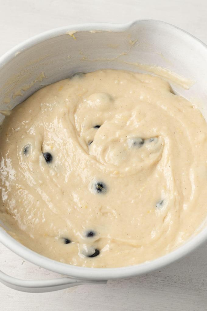 An overhead view of lemon blueberry quick bread batter in a large white mixing bowl.