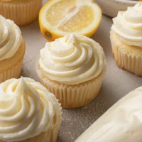 Several lemon cupcakes topped with lemon buttercream frosting.