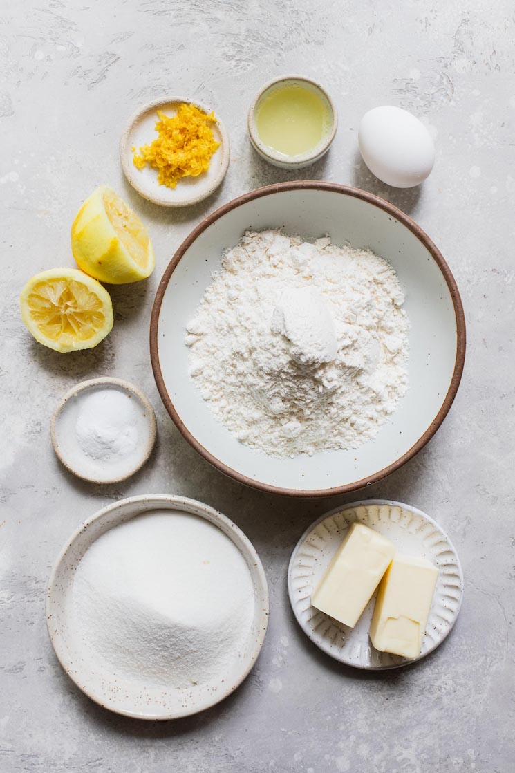 The ingredients needed to make lemon cookies sitting on top of a gray surface.