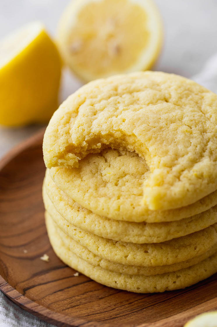 An upclose image of a stack of lemon cookies showing the bite taken out of the top cookie.