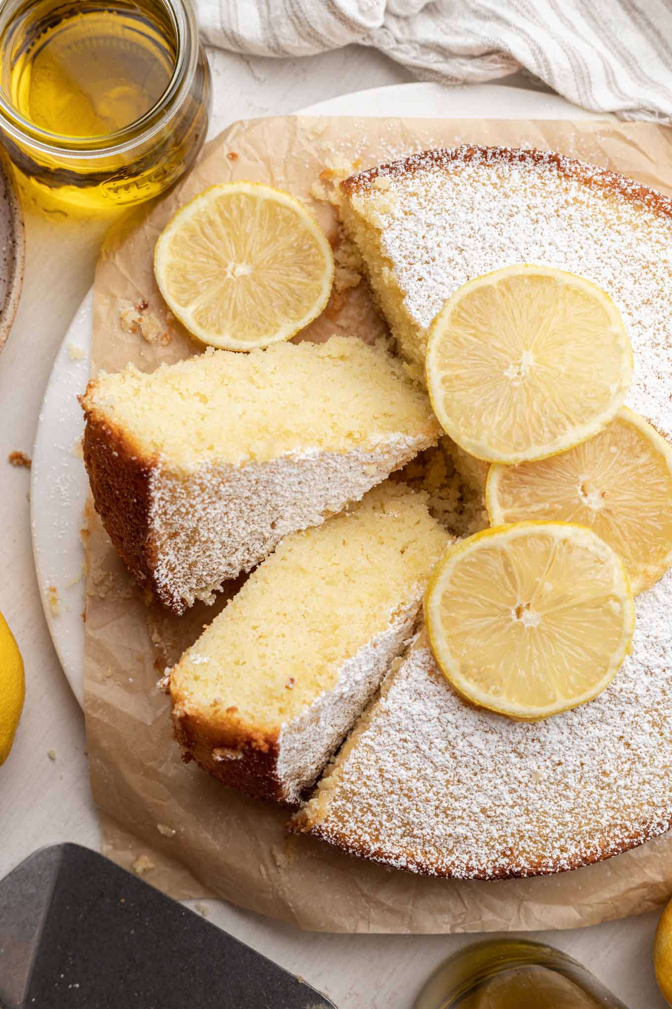 An overhead view of a lemon olive oil cake, with two slices turned on their sides. 