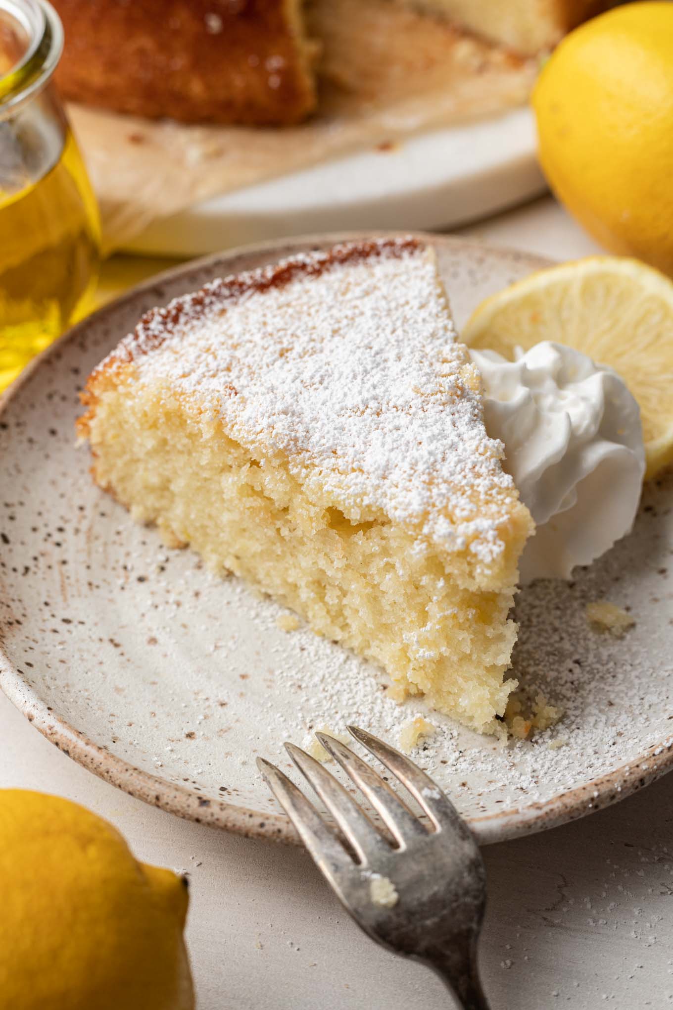 A slice of olive oil cake on a dessert plate. 