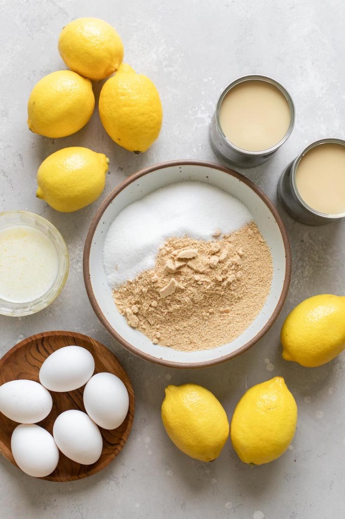The ingredients needed to make lemon pie laid out on a gray surface.