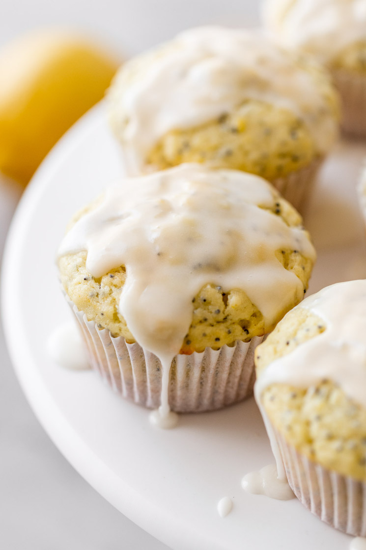 A close up of lemon poppy seed muffins with lemon glaze on top.