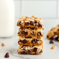 A stack of magic cookie bars on a marble surface.