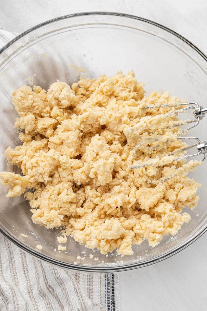 An overhead view of shortbread cookie dough in a glass mixing bowl.