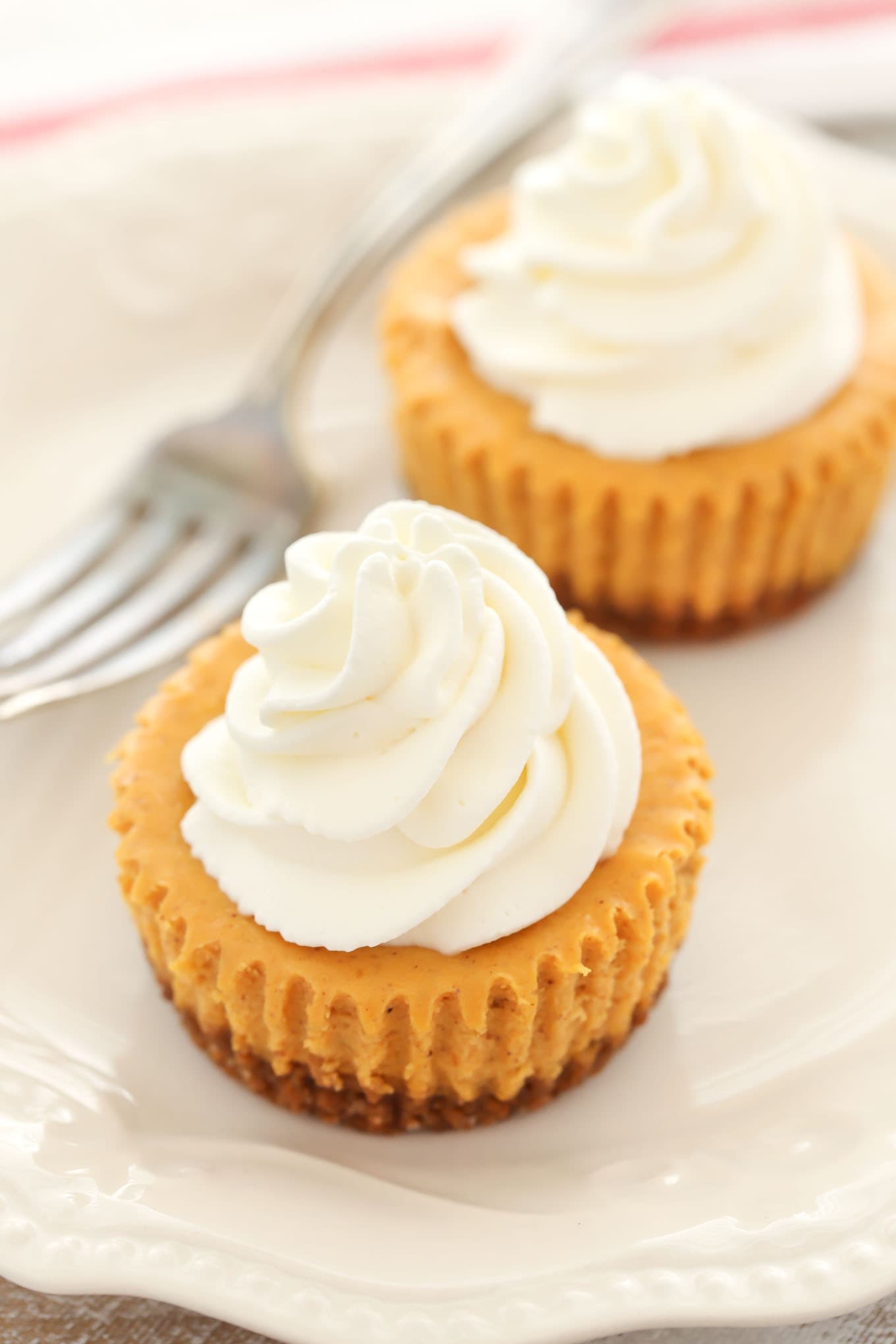 These Mini Pumpkin Cheesecakes feature an easy three ingredient gingersnap cookie crust with a smooth and creamy pumpkin cheesecake filling on top. These are the perfect mini dessert for fall!