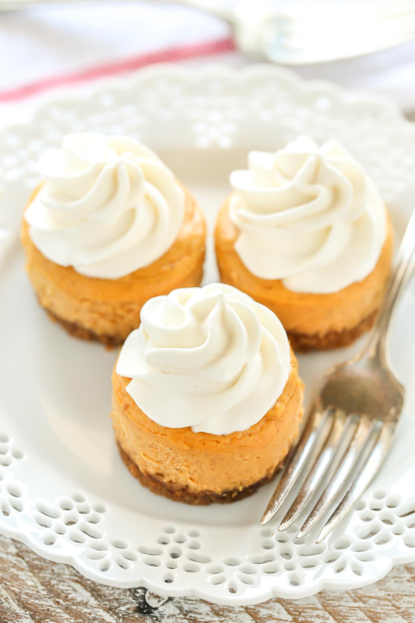 These Mini Pumpkin Cheesecakes feature an easy three ingredient gingersnap cookie crust with a smooth and creamy pumpkin cheesecake filling on top. These are the perfect mini dessert for fall!