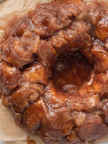 An overhead view of monkey bread on a piece of brown parchment paper.