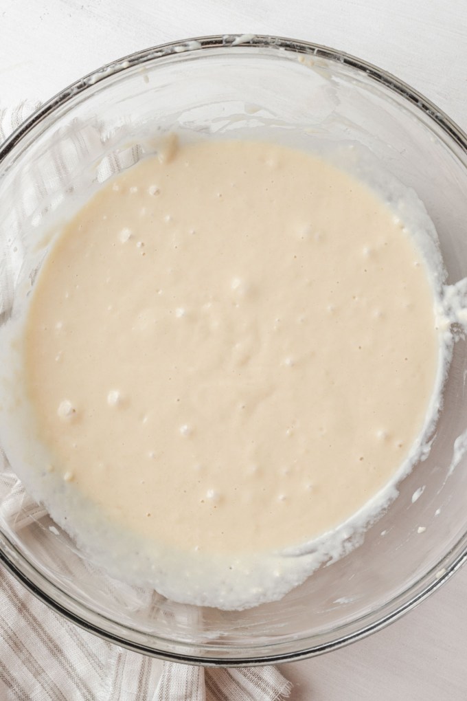 Overhead view of unproofed monkey bread dough in a glass mixing bowl.