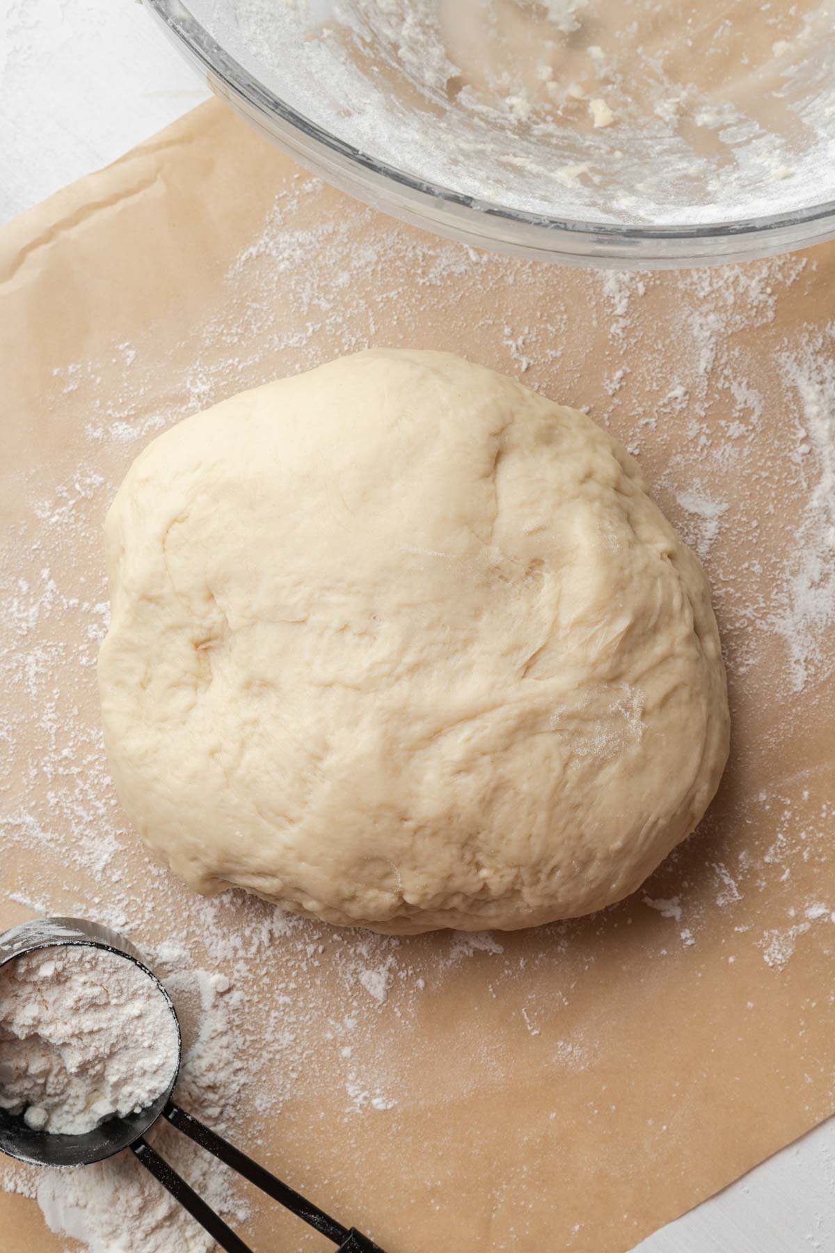 A ball of homemade dough on parchment paper.