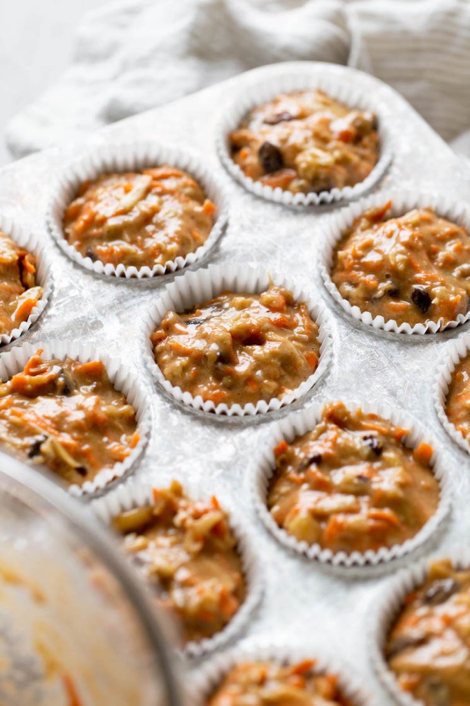 Unbaked morning glory muffins in a muffin tin, ready to be baked.