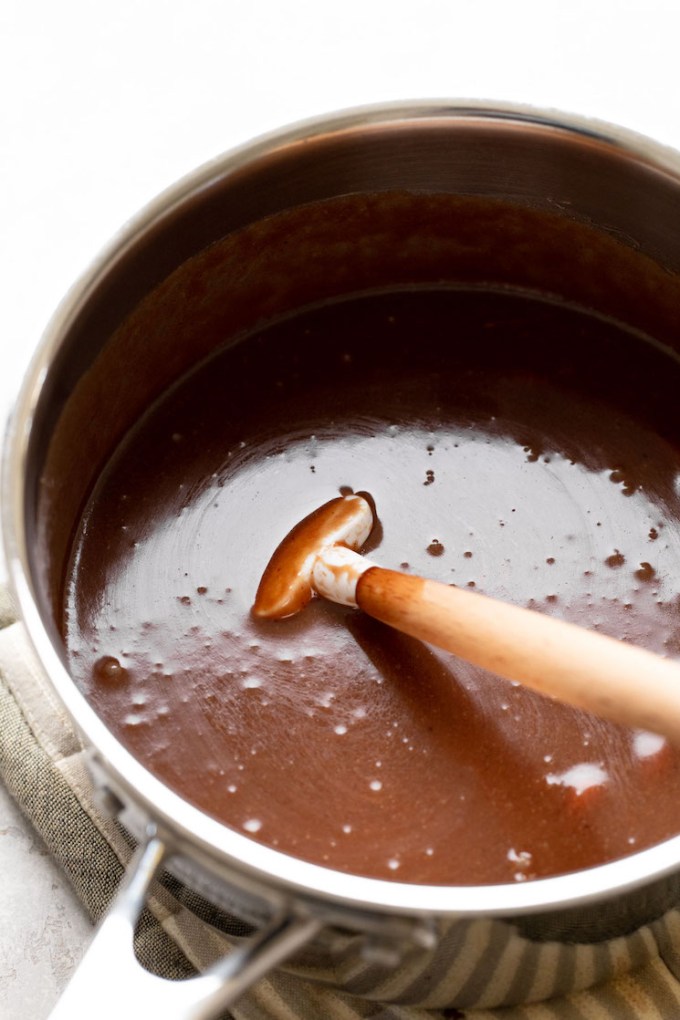 The no-bake cookie mixture in a large saucepan after the peanut butter and vanilla has been mixed in. A rubber spatula rests inside the saucepan.