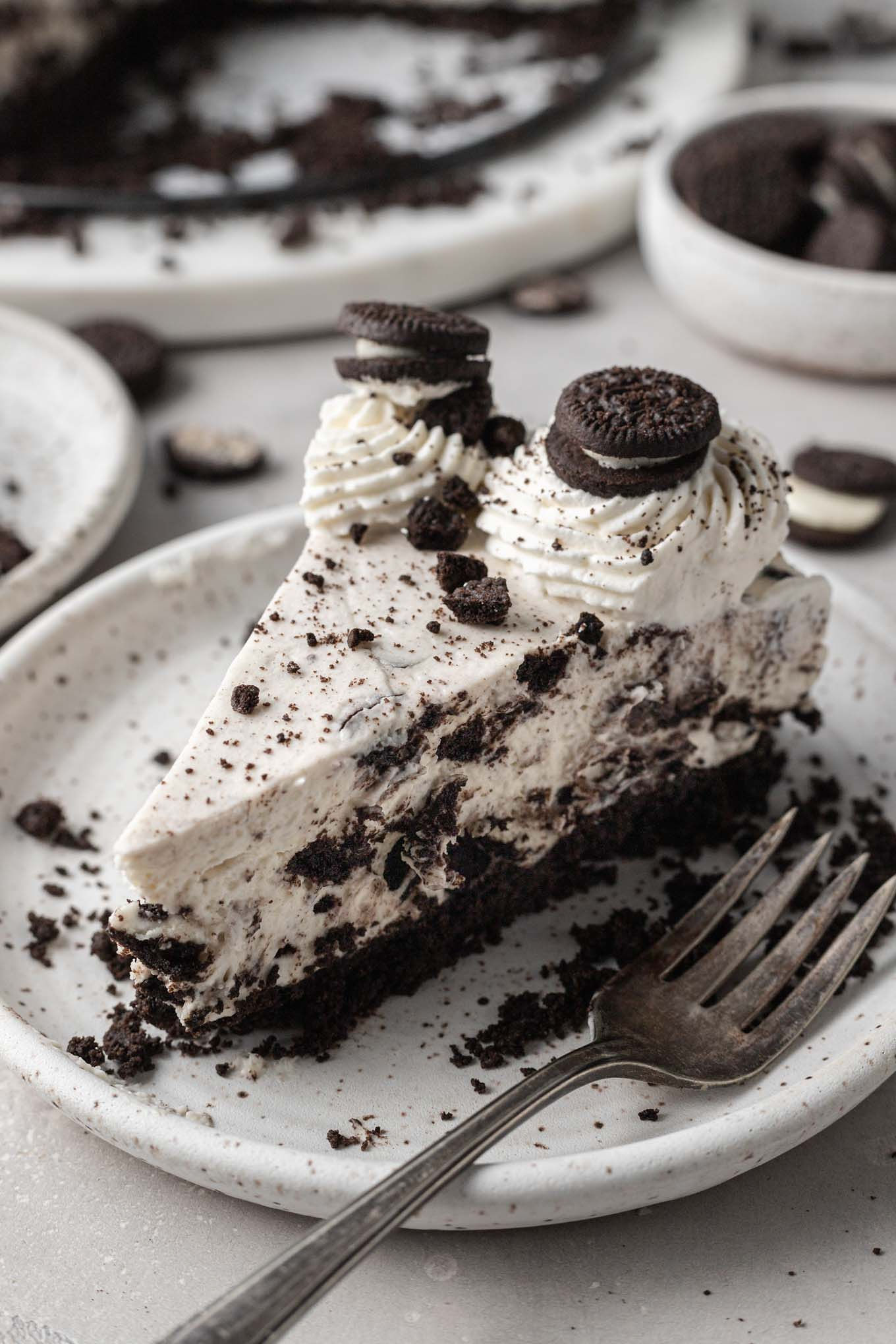 A slice of no bake Oreo cheesecake on a dessert plate. 