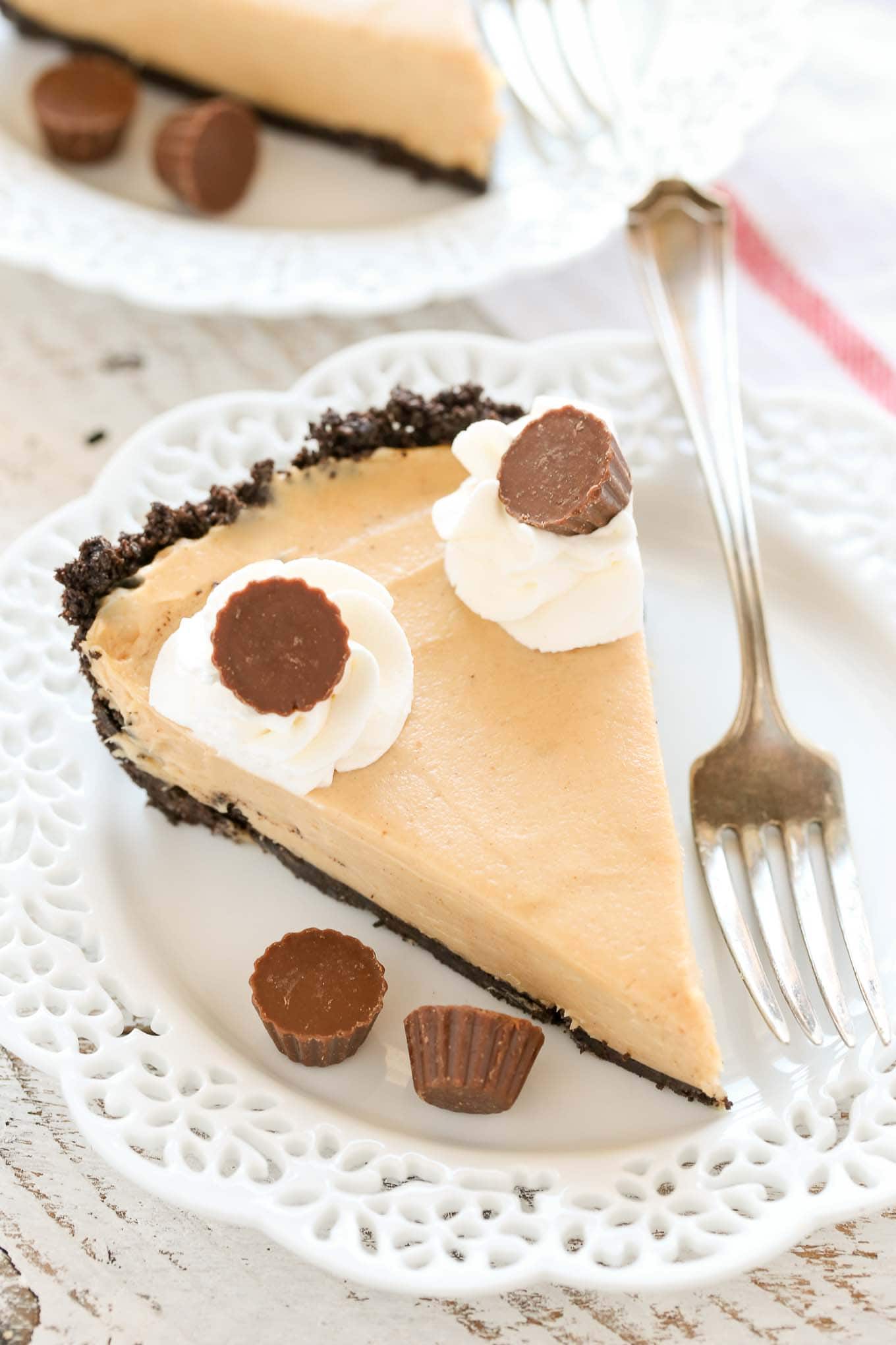 A slice of no bake peanut butter pie on a white plate with a fork. 