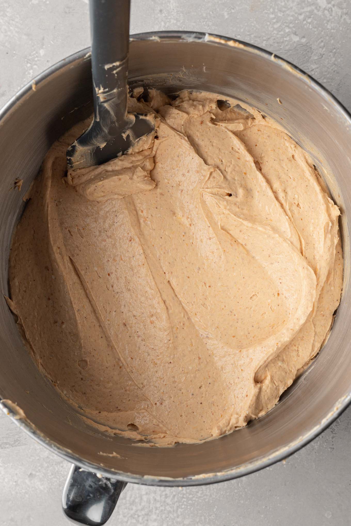 An overhead view of no bake pumpkin cheesecake filling in the bowl of a stand mixer.