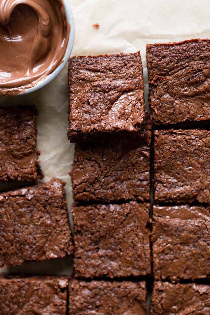 A close up overhead view of sliced Nutella brownies and a dish of Nutella. 