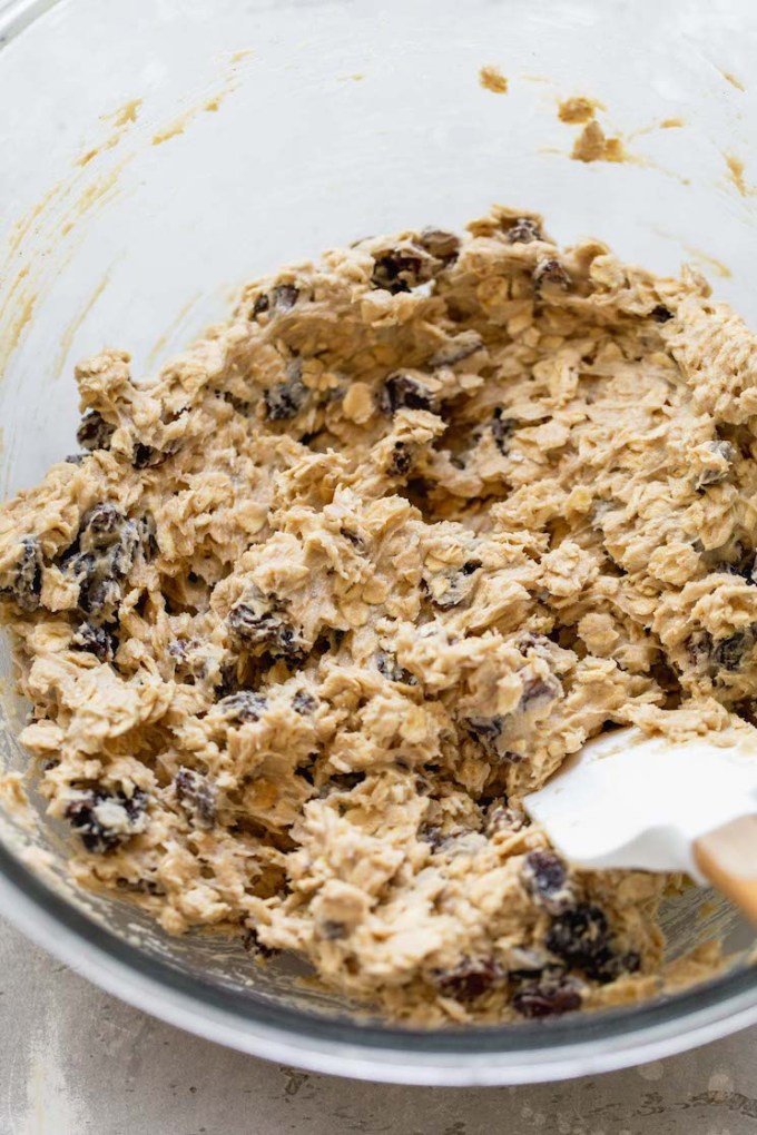 A glass mixing bowl holding the finished cookie dough ready to be scooped onto baking sheets.