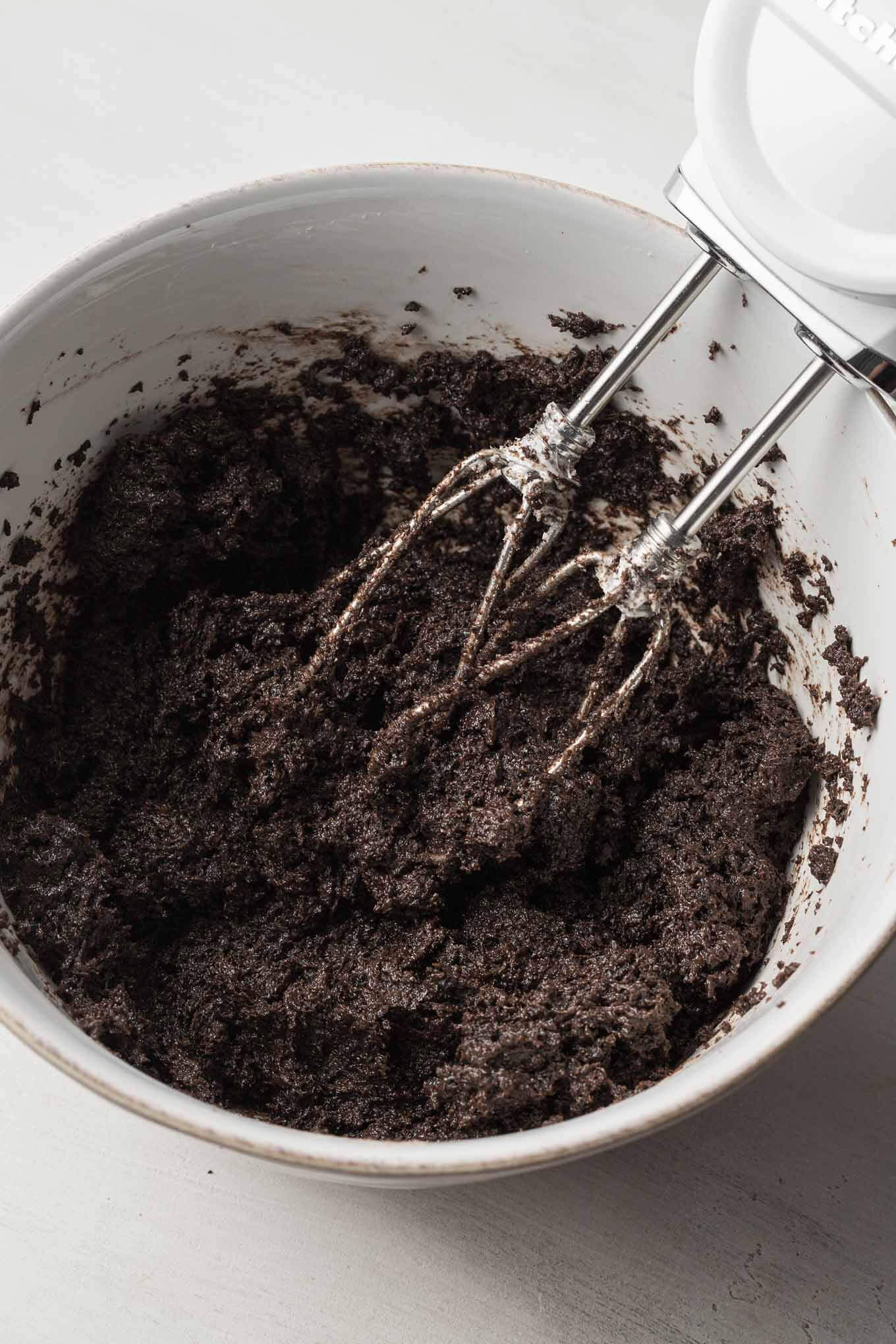 A white mixing bowl with an Oreo cream cheese mixture.