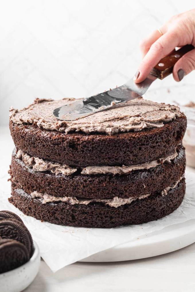 A process shot showing an Oreo cake being decorated.