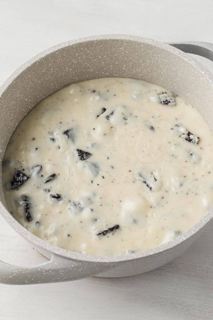 An overhead view of a white chocolate Oreo mixture in a saucepan.