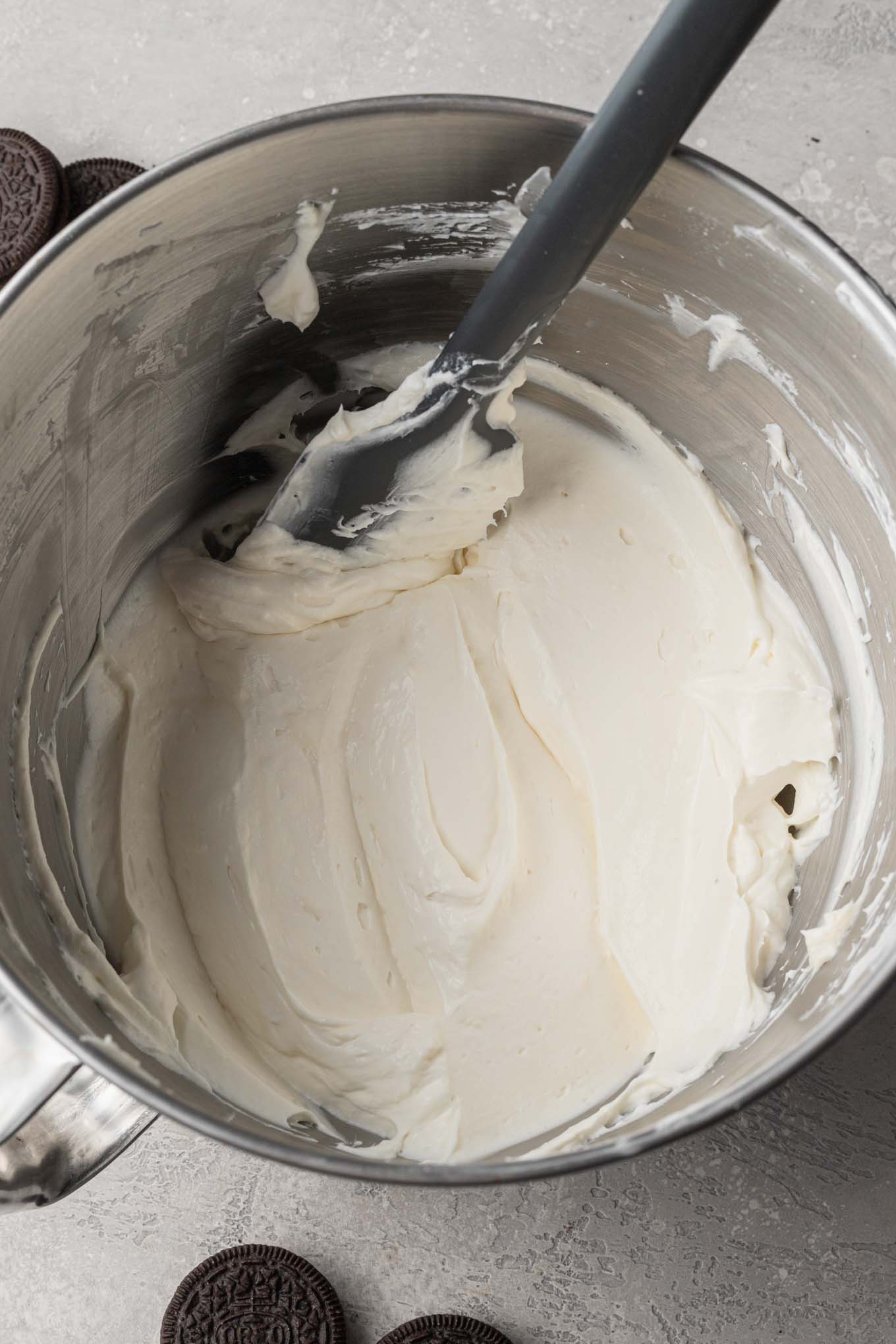 An overhead view of whipped cream being folded into the cream cheese mixture.
