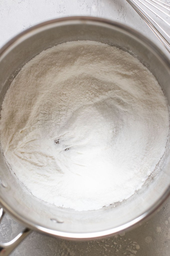 Overhead view of a saucepan filled with cornstarch and sugar.