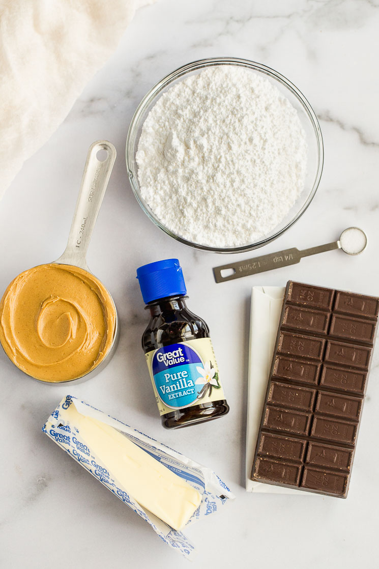 The ingredients needed for chocolate covered peanut butter balls on top of a marble surface. 