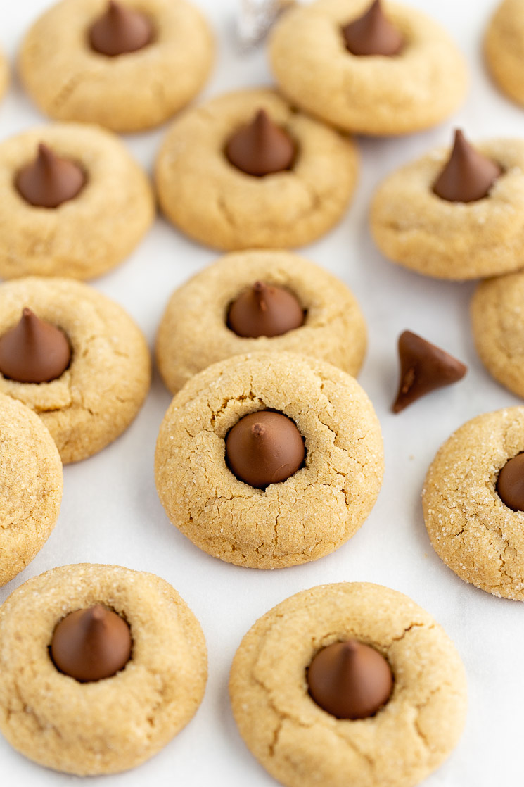 A baking sheet covered in peanut butter blossoms with chocolate kisses mixed in.